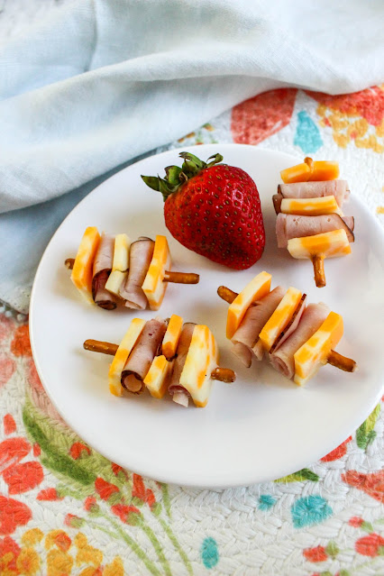 Ham and Cheese Pretzel Kabobs on a white plate with a floral background.