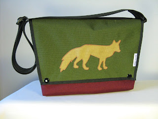 A photograph of an overshoulder handbag made of heavy nylon fabric in autumnal with a fox on the front flap that was sewn by Aramee Diethelm