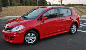 Side view of red 2011 Nissan Versa parked