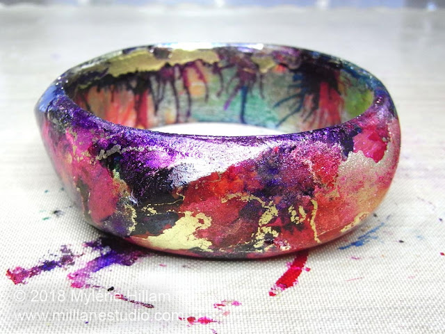 Red, blue and purple alcohol inks blended together with gold marbling on a resin bangle base.