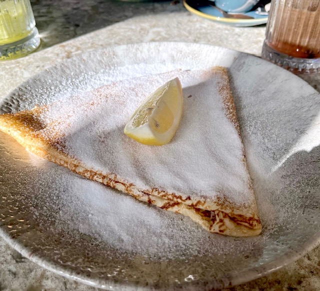 a folded pancake with a lemon wedge on top