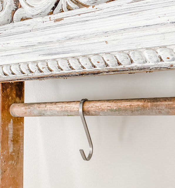 silver "S" hook hanging from vintage ladder