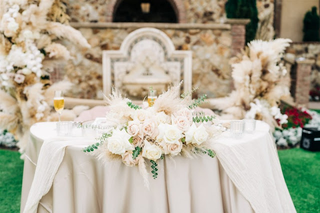 sweetheart table with nude linen and floral rose centerpiece