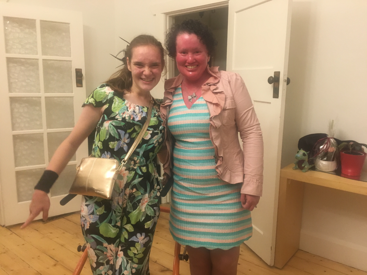 Photo of Stella Barton and Carly Findlay. they are both smiling and are dressed fabulously in green and pink.