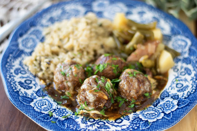 A plate of the french onion meatballs with rice and green beans.