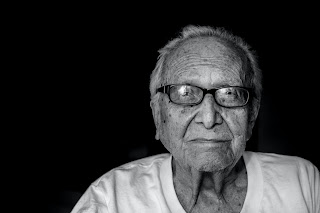 An elderly man looking forward.