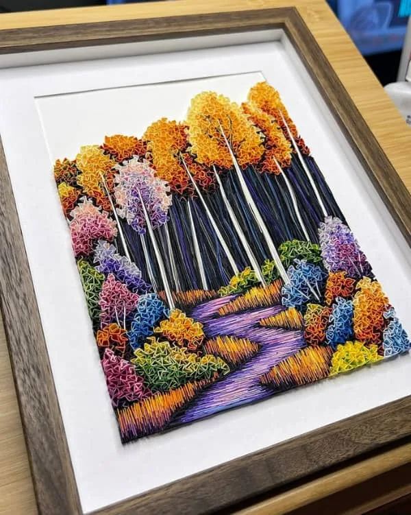Vibrant quilled dimensional landscape by Hannah Gebhart displayed in rectangular wooden frame.