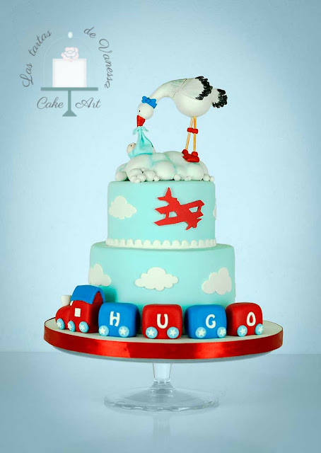 tarta de fondant bautizo cigüeña, tren y avión azul, rojo y blanco