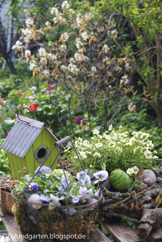 Gartentisch mit Vogelhäuschen und Osterkranz