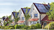 A row of houses with solar panels mounted on their roofs.