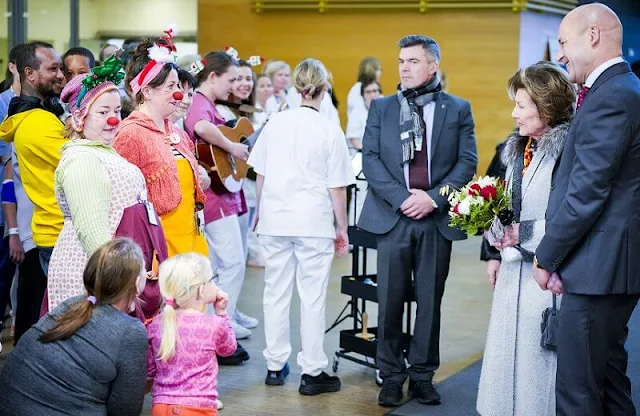 Queen Sonja visited the Children's and Youth Clinic at Akershus University Hospital. Sonja wore a red dress and grey fur collar coat