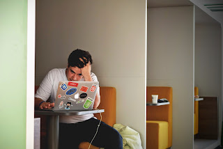 a man at his laptop looking stressed