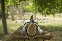 man lying below a tree (enjoying in tree's shade)