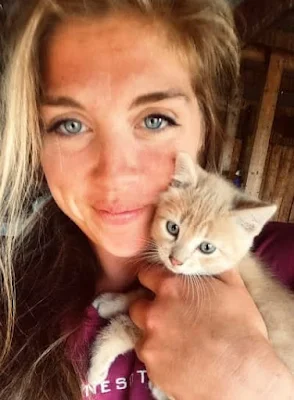 smiling young woman holding kitten