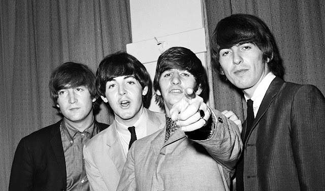 Ringo Starr apunta a la cámara mientras sus compañeros de los Beatles John Lennon, Paul McCartney y George Harrison están a su lado en el backstage de una actuación benéfica en el Paramount Theatre de Manhattan