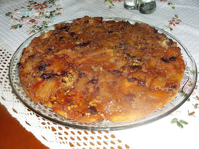 κέικ με μήλα σε μία πολύ ωραία γιάλινη πιατέλα πάνω σε τραπέζι που είναι στρωμένο με κεντητό τραπεζομάντηλο