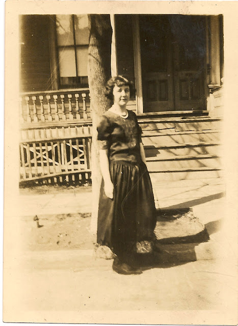 Photo of unidentified woman, probably a Dixon, standing at the curb in front of a house. Between 1920-1940. Printed in Elizabeth, NJ at Graham & McCloskey.