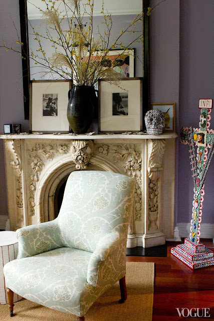 living room with lavender walls, a black mirror, framed portraits of Diego Rivera and Frieda Kahlo, and a marble fireplace mantel with a black and white skull