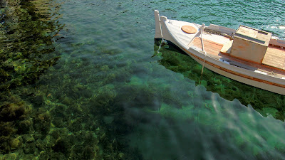 Wallpaper on coral under clean water. Half of a boat is visible at the right side of the image.  The combination of all makes the wallpaper outstanding.