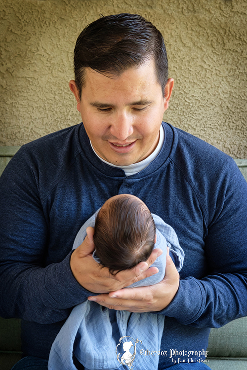 Professional portrait of a newborn baby and family outside