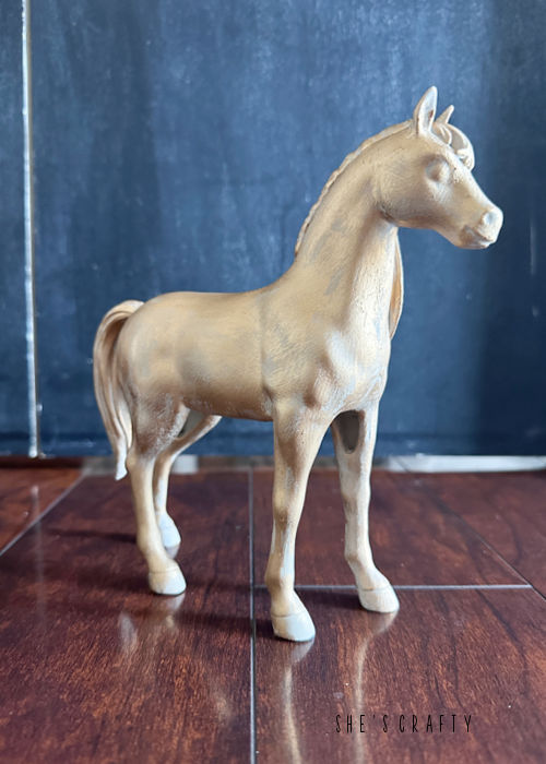 Painted horse statue with gold rub and buff.