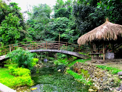 hover_share Scenic arc bridge crossing a lovely stream and Nipa hut at Mag-aso Falls Leisure Camp