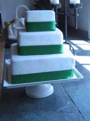 Vivid dark green satin ribbon on simple white icing wedding cake