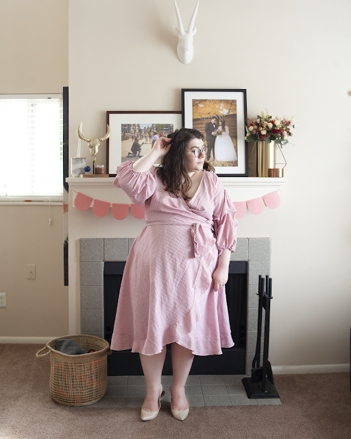 An outfit consisting of a pink and white striped wrap dress with 3/4 princess sleeve and beige slingback heels.