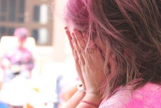 trying to hide her face because of holi colour , happy holi friends