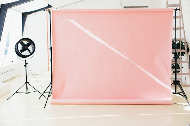 A photography studio featuring a peach backdrop.