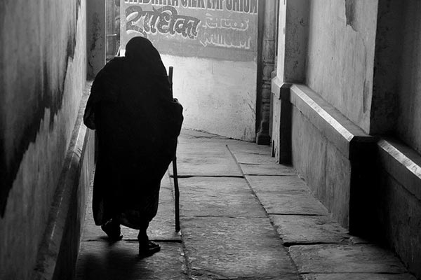 Viuda India camiando por una callejuela de Varanasi.