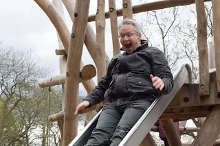 A daddy enjoying going down the slide