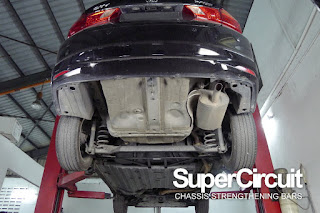 The full undercarriage chassis of the 6th generation Honda City (code GM6) with the SUPERCIRCUIT Rear Lower Brace installed.