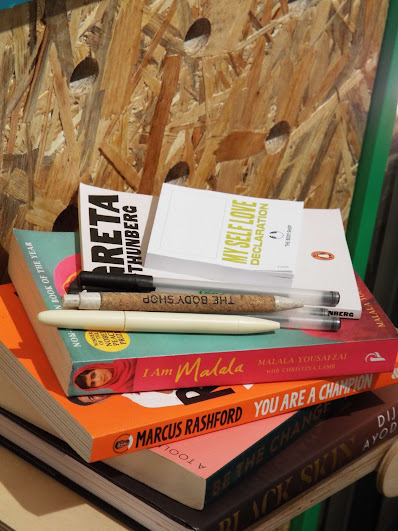 Pile of inspirational activism books at the community and activism wall, including Greta Thunberg, I am Malala and Marcus Rashford.