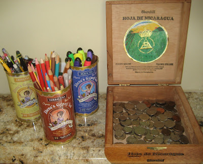 cigar box with coins, and tea tins with pens