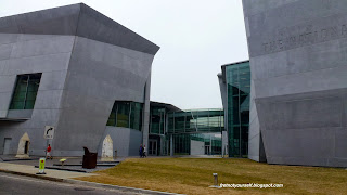 Large, monolithic buildings of battleship grey stone and tempered glass house the Victory Theater and large exhibit halls at the World War II Museum