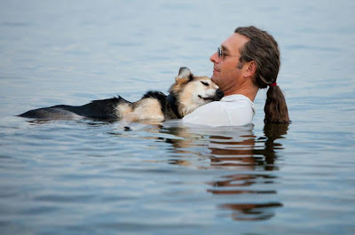 Hombre y perro en el agua