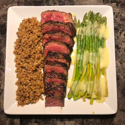 Rare grilled New York strip, steamed asparagus with hollandaise and porcini mushroom farro