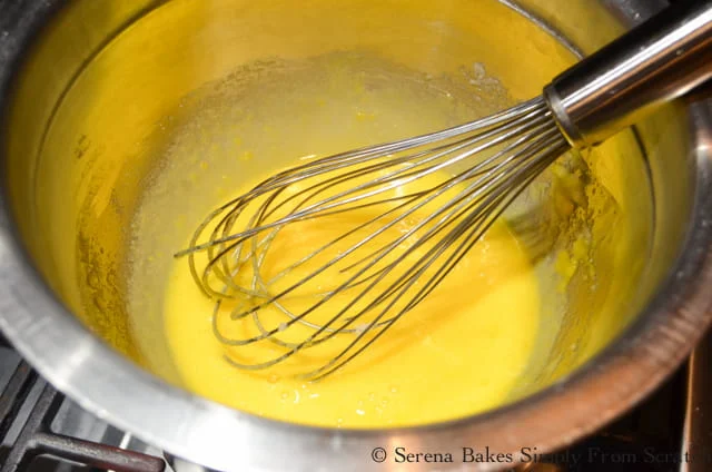 In the top of a double boiler whisk together egg yolks, rum, sugar until light and fluffy.