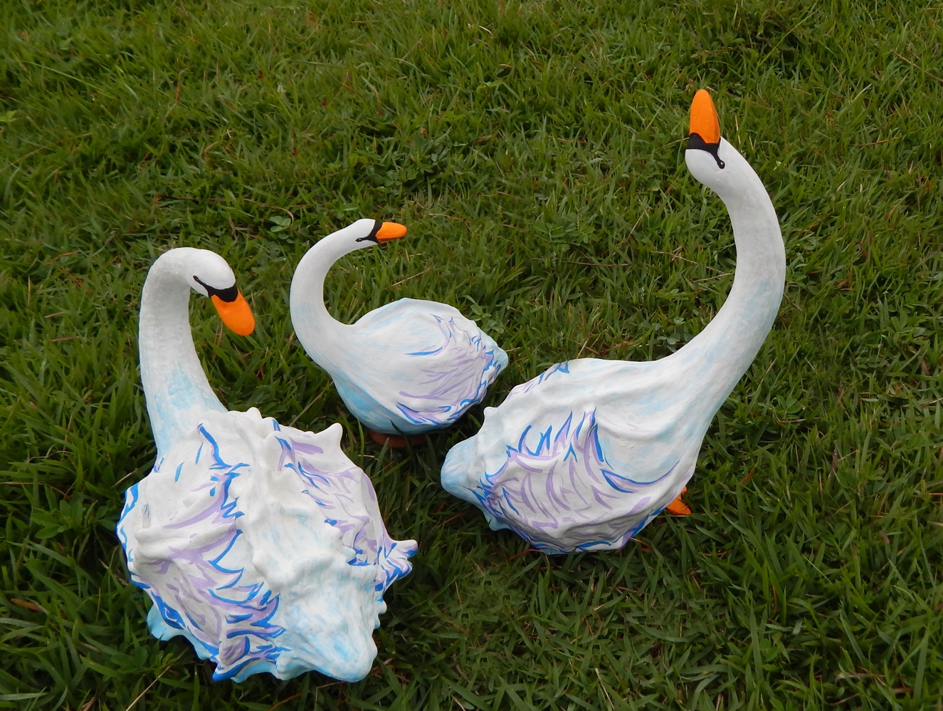 Tres graciosos cisnes na grama, feitos a partir de cabaças-jacaré 