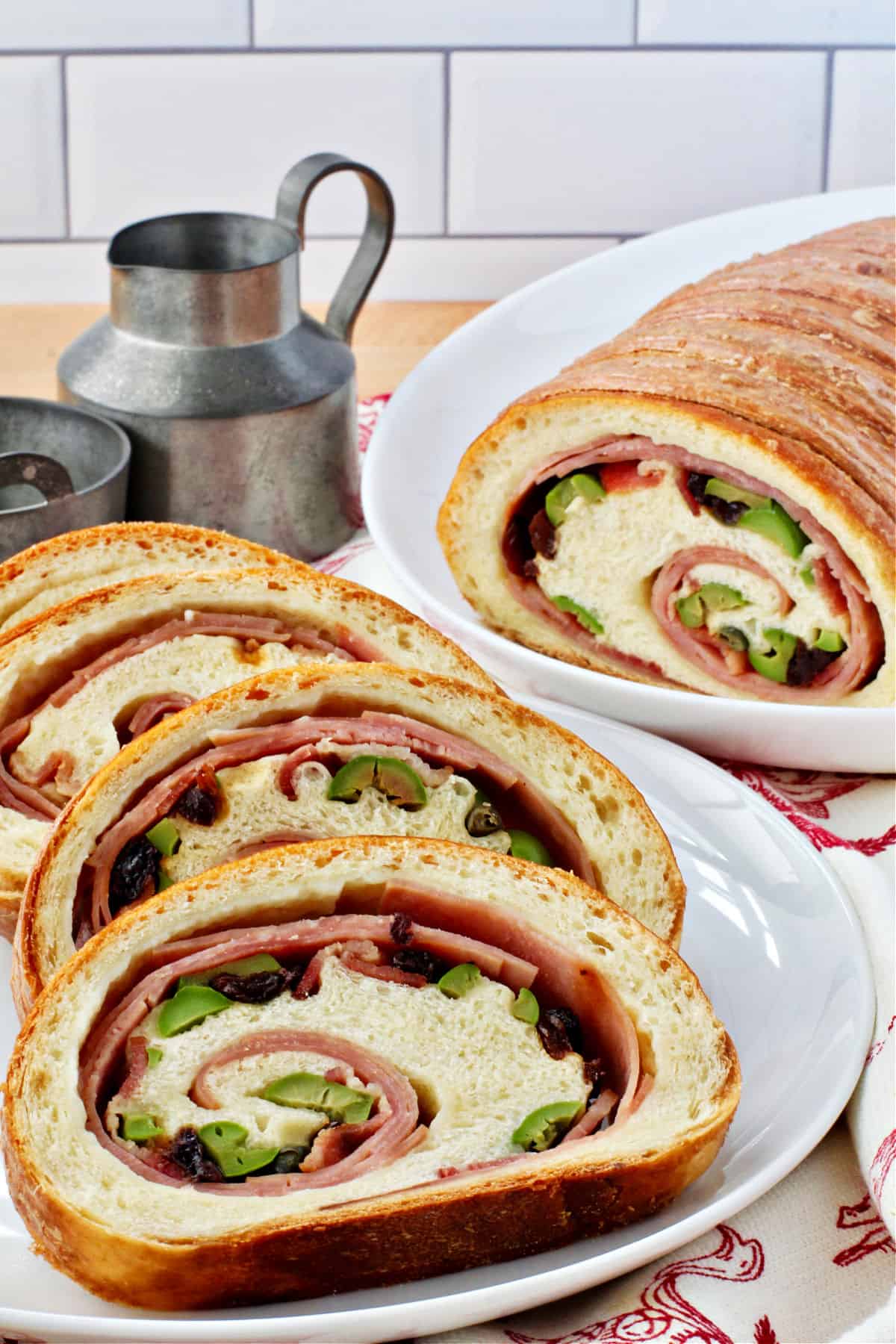 Venezuelan Christmas Ham Bread sliced on a white platter.