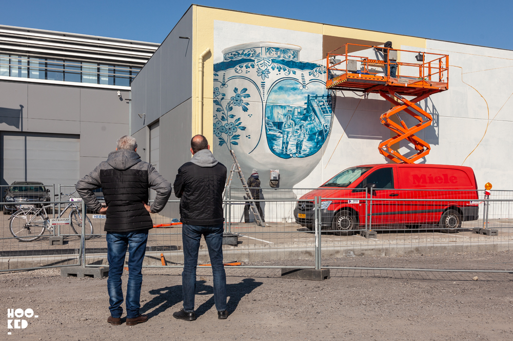 Onlookers watch artist Leon Keer at work on his 3d mural in ostend