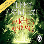 Green audiobook cover; the title is bordered by witches on broomsticks