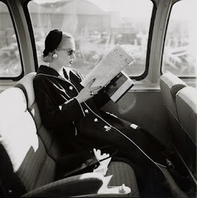 black and white image of woman reading on train 