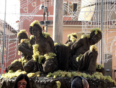 Fuente de los Cuatro Moros adornada con racimos de uvas.