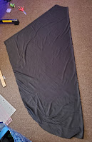 The back panel of the bata, cut on the fold, laid out on the floor.