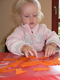 young child making a tissue paper sun catcher craft