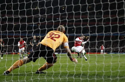 Arsenal forward Robin van Persie scores from the penalty spot against AC Milan