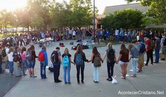 Estudiantes orando en escuela