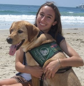 Elizabeth Kaufman with yellow Lab puppy at beach